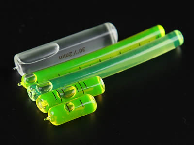 Four glass tubular bubble level vials in different precision on the black background.